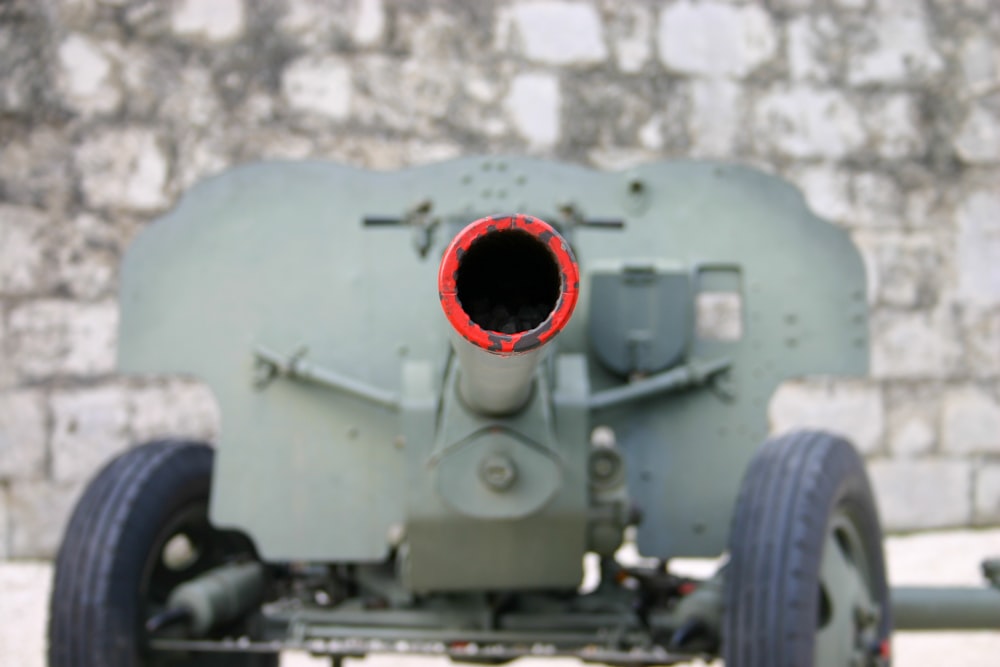 a close up of a military vehicle with a brick wall in the background