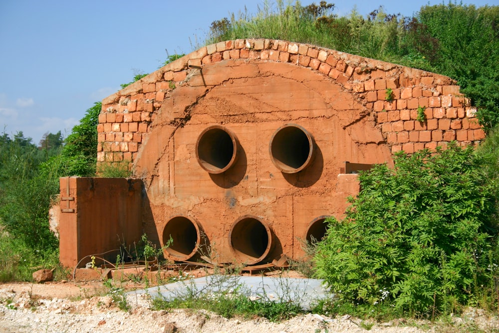 a red brick structure with three large round holes