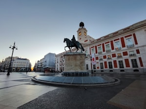 a statue of a man riding a horse in front of a building