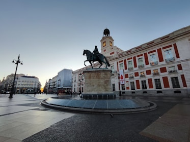 a statue of a man riding a horse in front of a building
