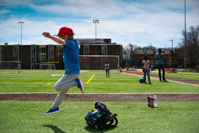 a young boy jumping in the air on a baseball field