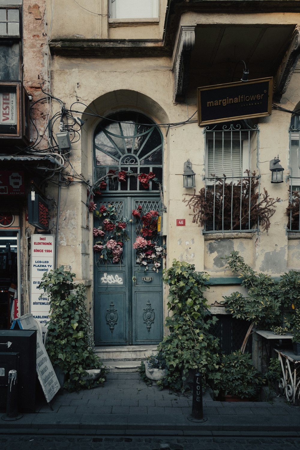 a building with a green door and a bunch of plants