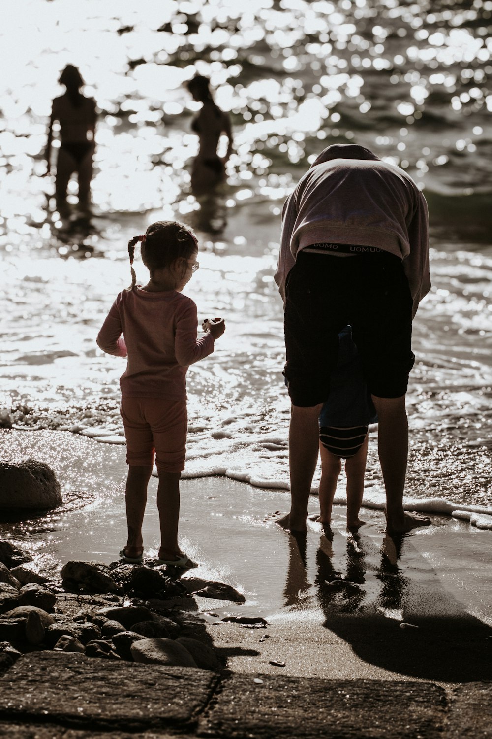 a little girl standing on top of a sandy beach