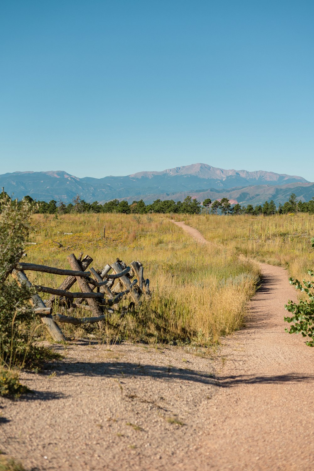 a wooden fence sitting on top of a dirt road