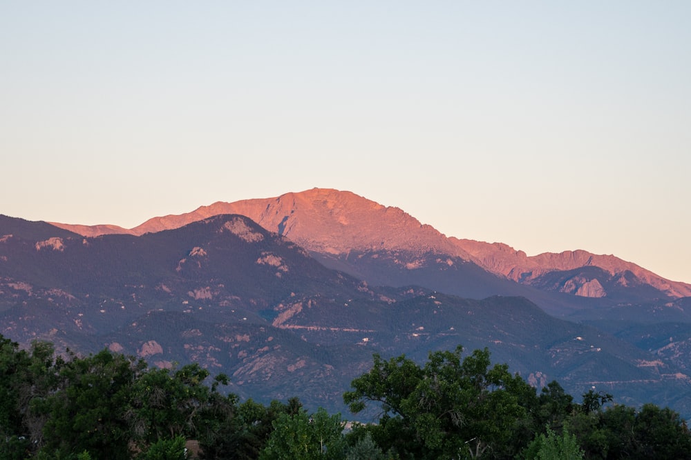 a view of a mountain range with trees in the foreground