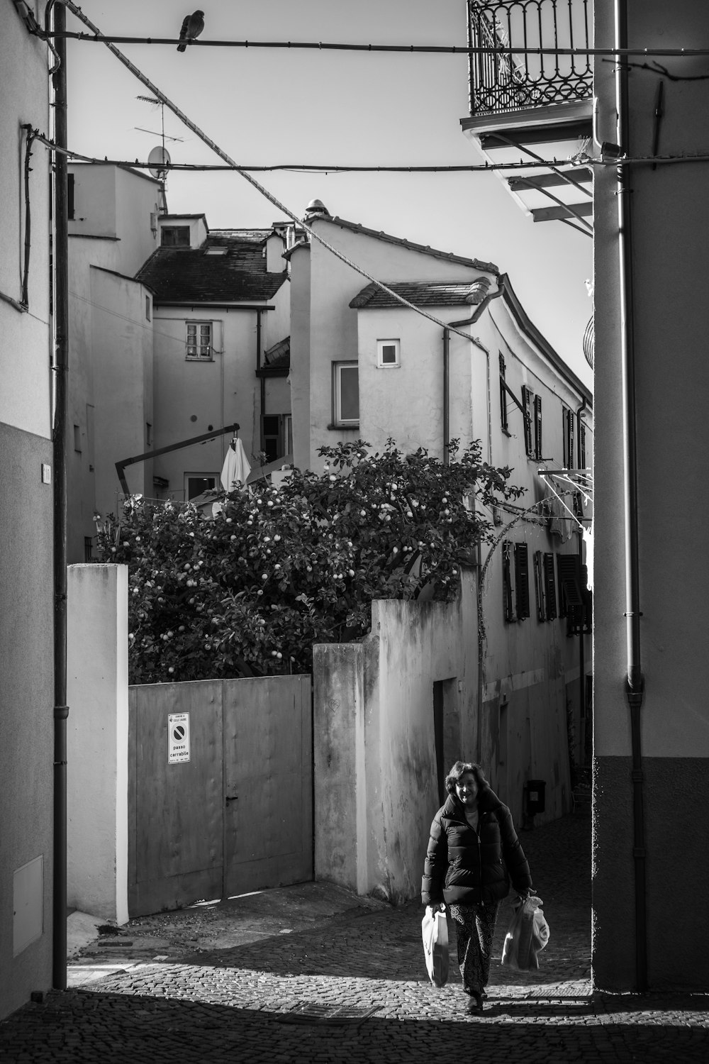 uma foto em preto e branco de uma pessoa andando por uma rua