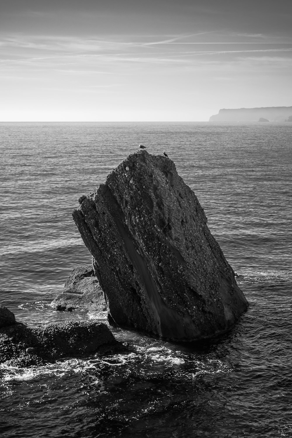 a large rock sticking out of the ocean