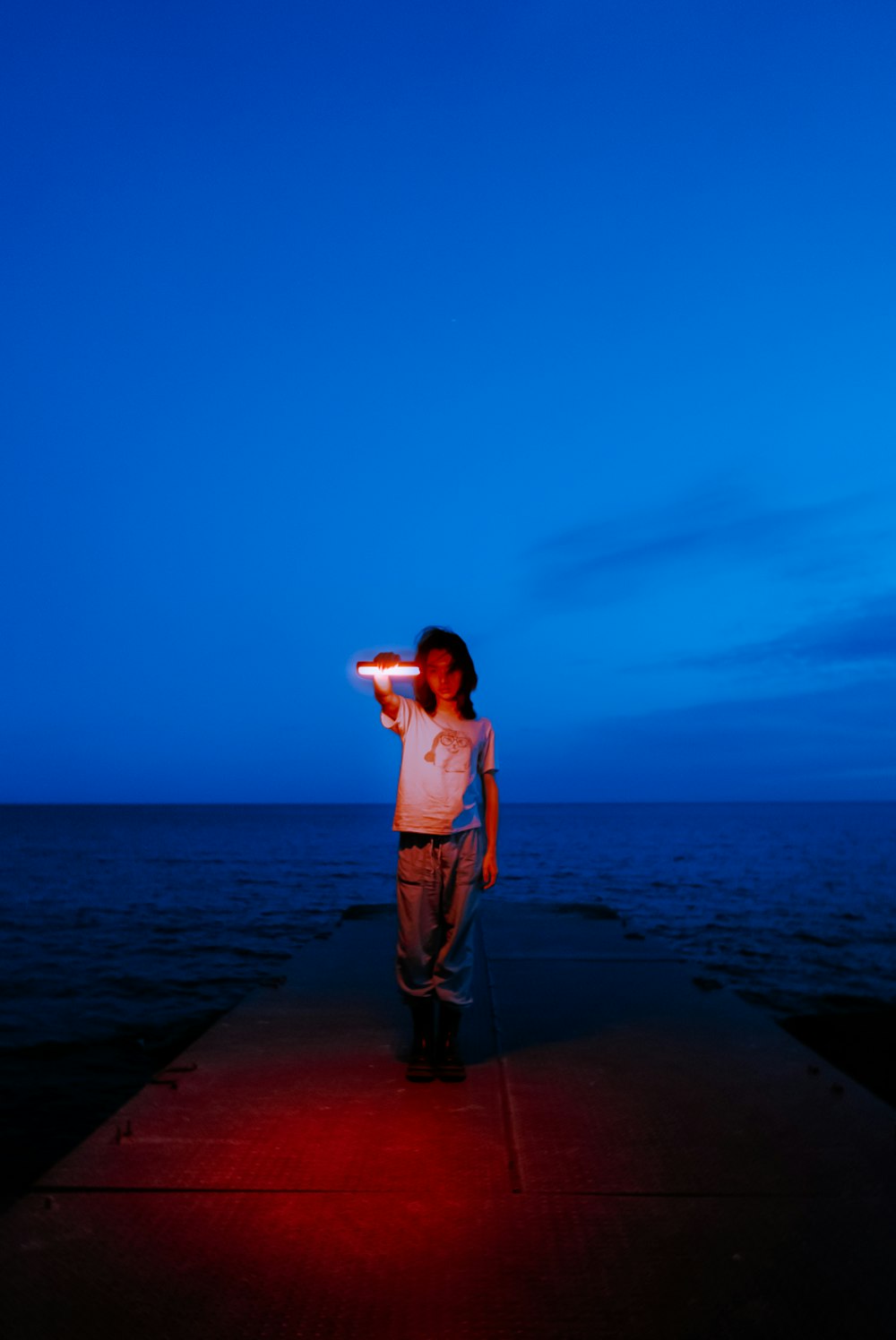 a person standing on a pier with a light on
