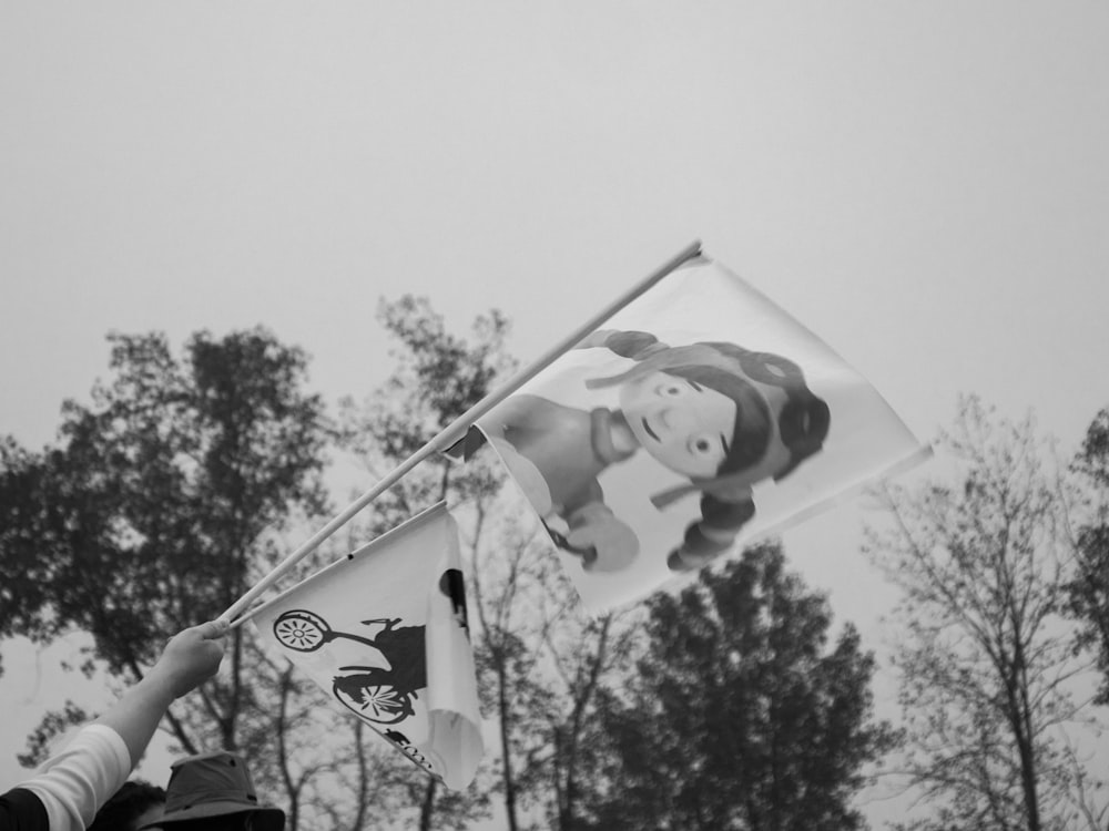 a black and white photo of a person holding a kite