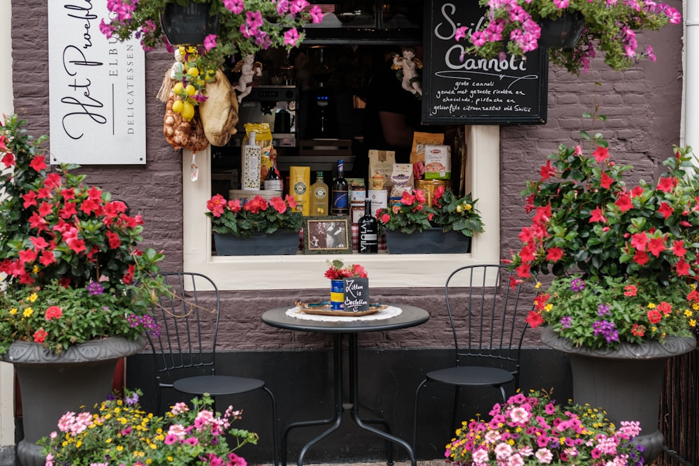 a table and chairs outside of a flower shop