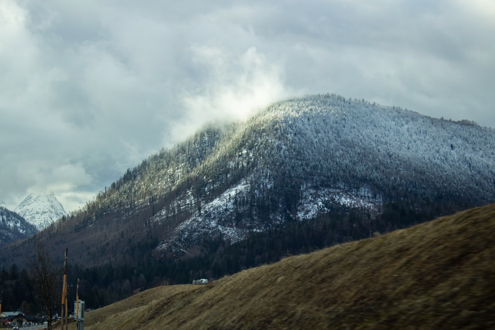 a mountain covered in snow with a cloudy sky