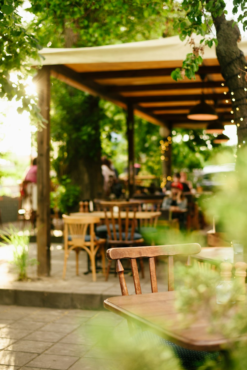 a wooden table and chairs under a canopy