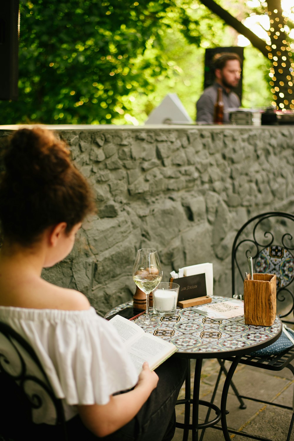 a woman sitting at a table with a glass of wine