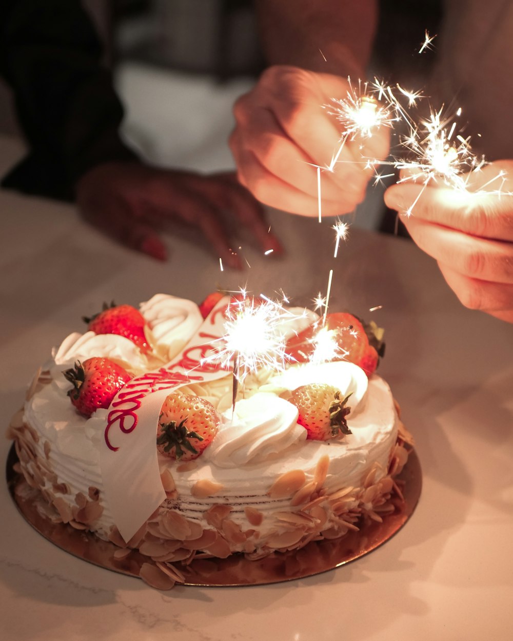 a person lighting a sparkler on top of a cake