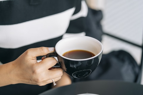 a woman is holding a cup of coffee