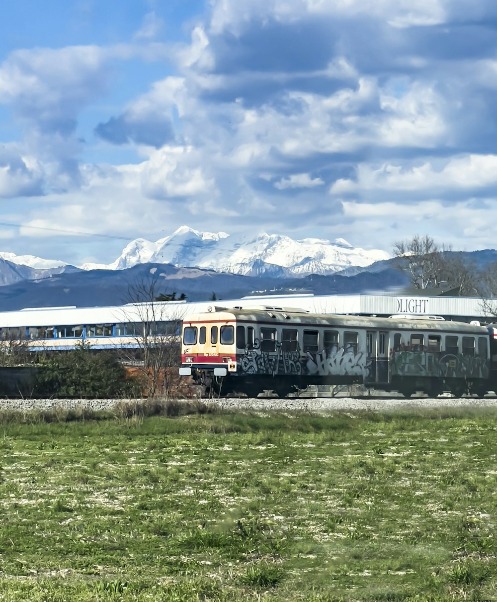 a train on a track with mountains in the background