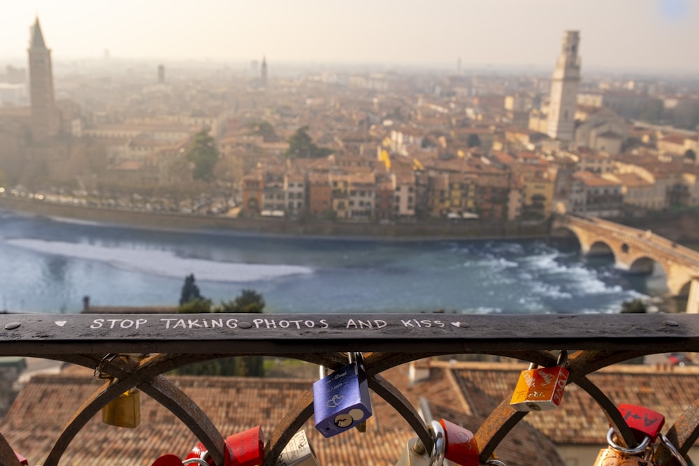 a view of a city from a bridge with padlocks on it