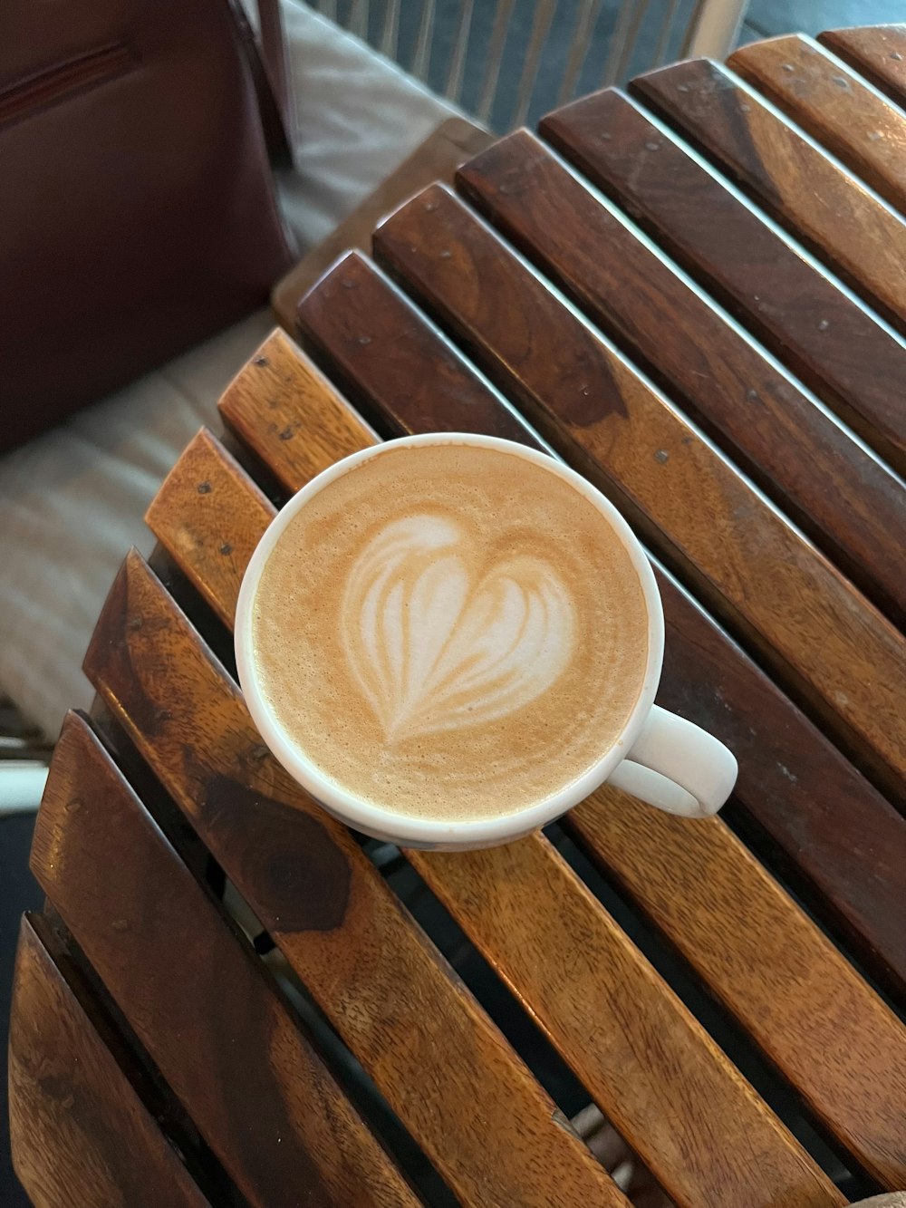 a cup of cappuccino on a wooden table