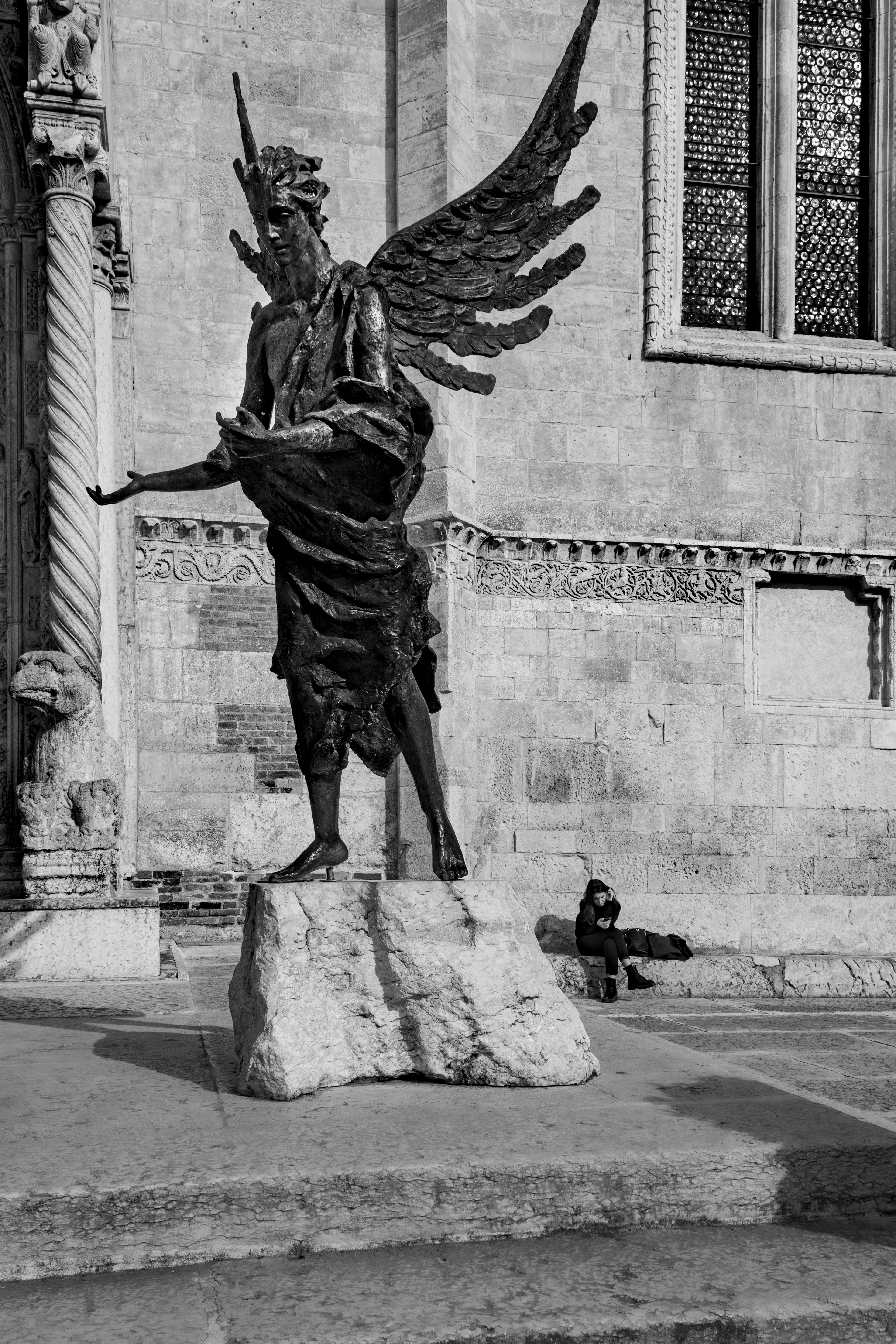 Una foto en blanco y negro de una estatua frente a un edificio