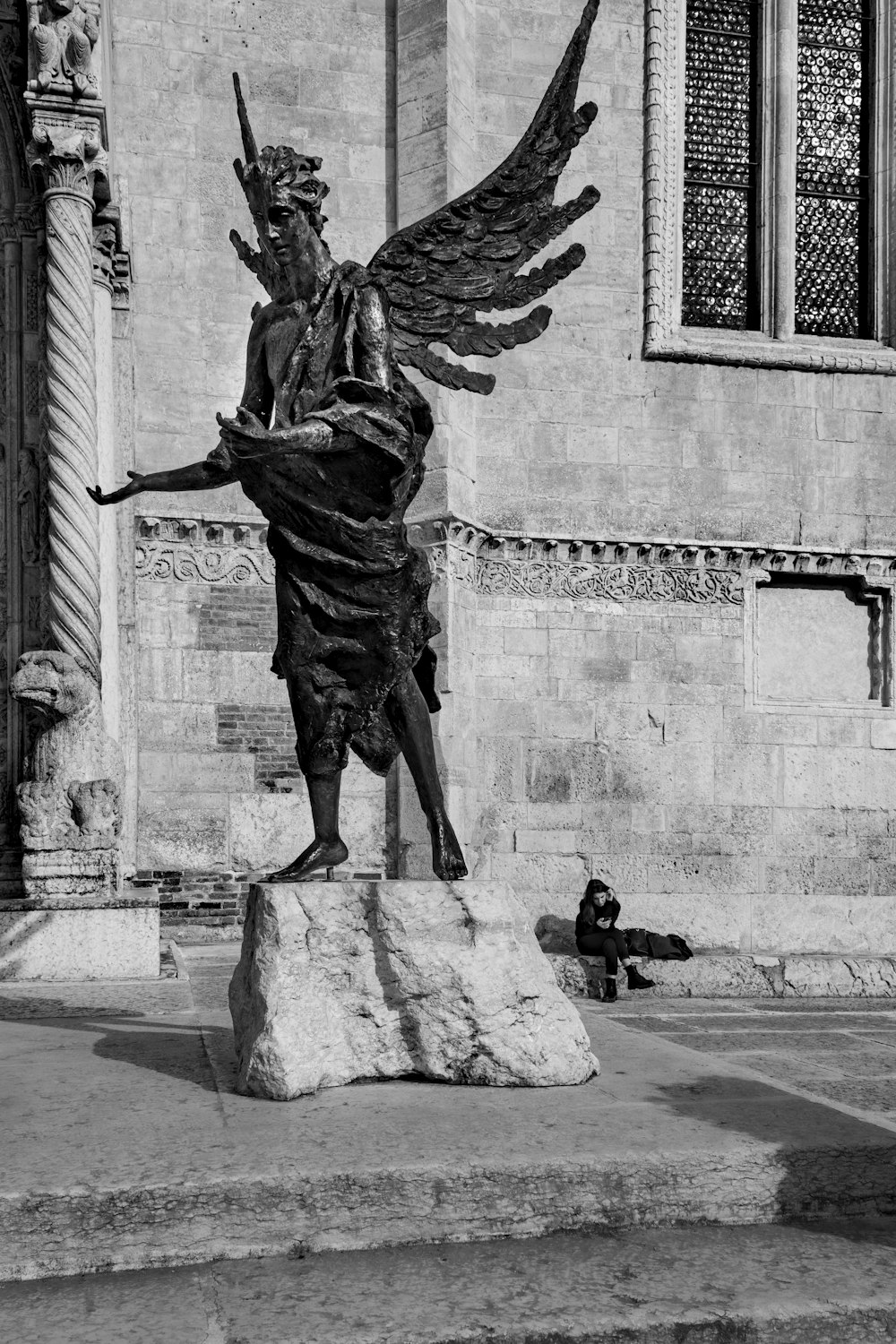 a black and white photo of a statue in front of a building