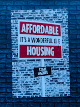 a red and white sign on a brick wall