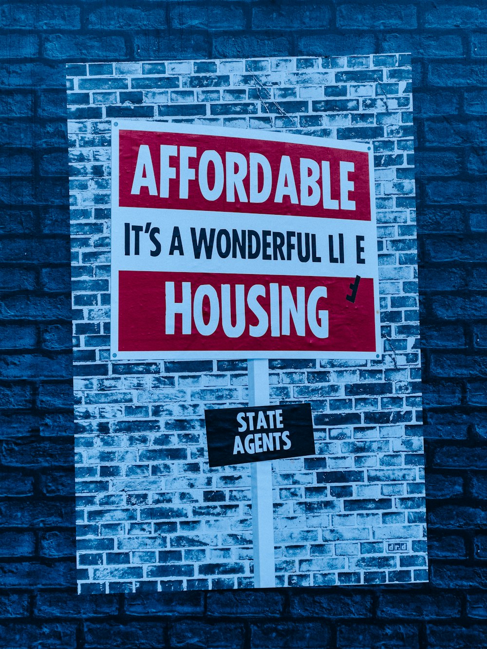 a red and white sign on a brick wall