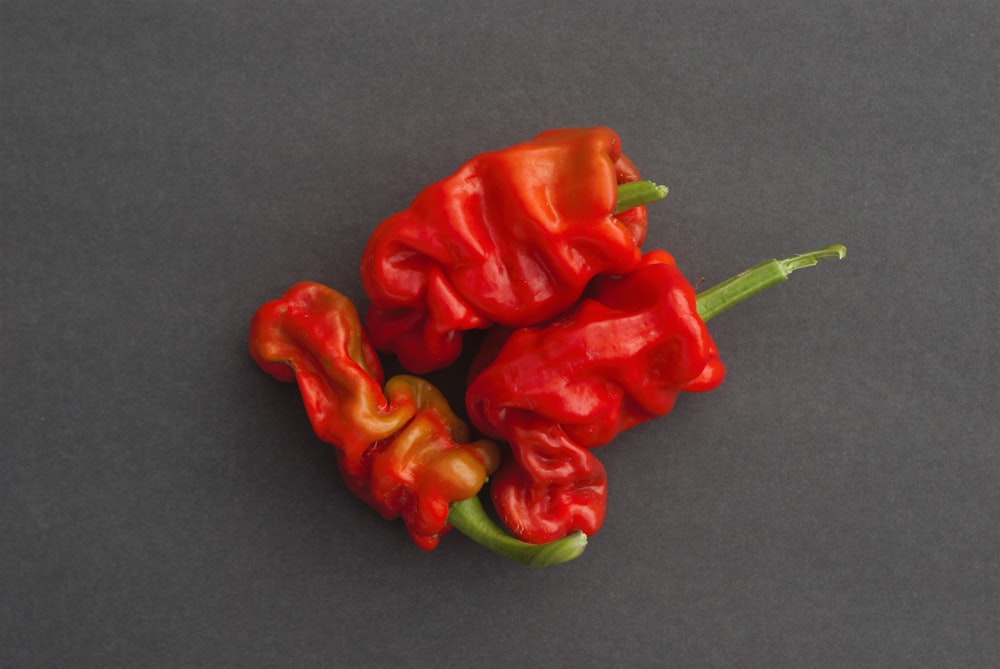 a couple of red peppers sitting on top of a table