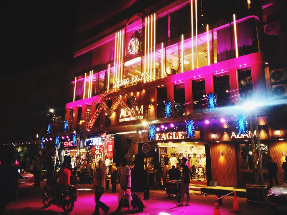 a group of people standing outside of a building at night