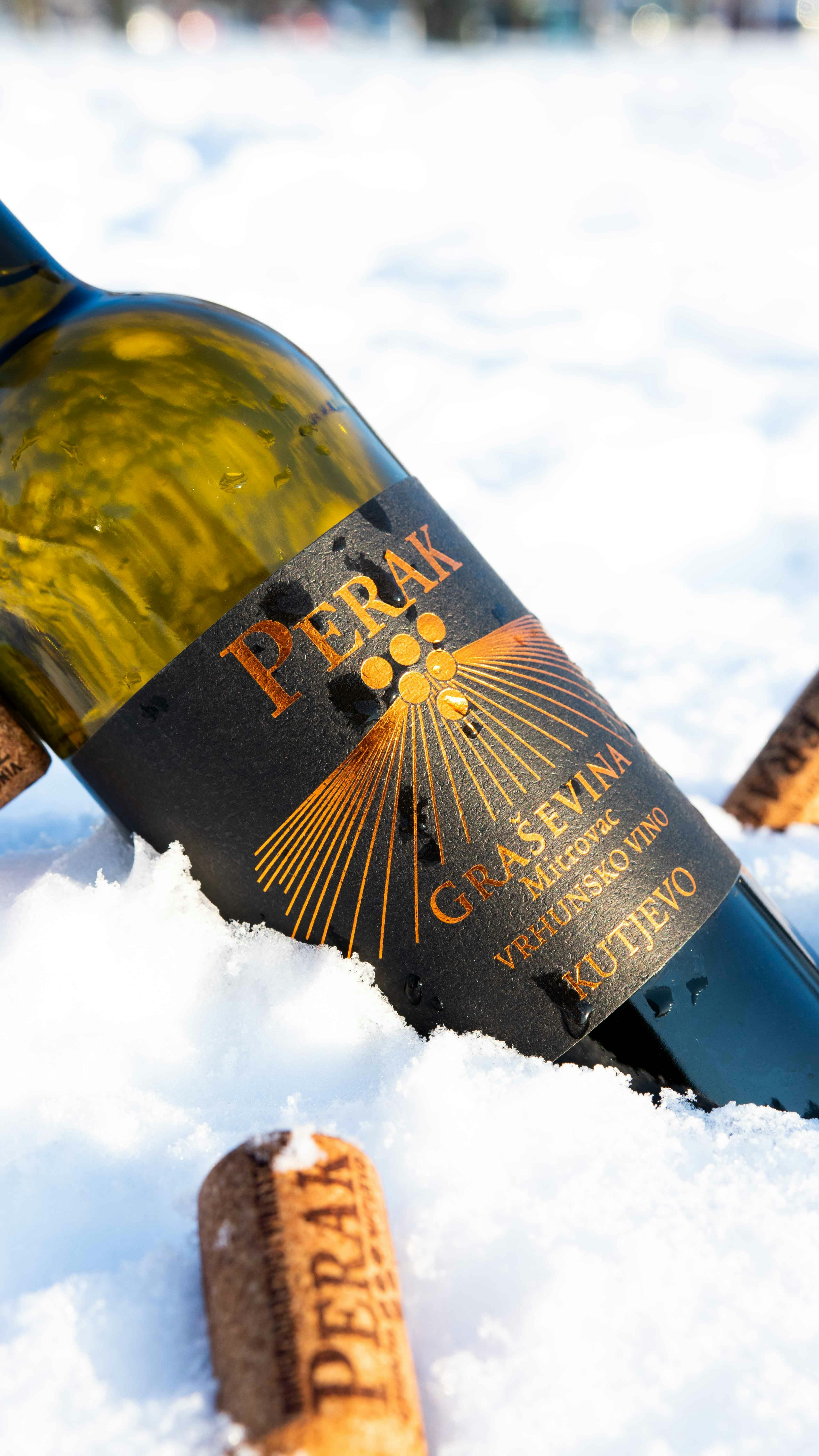 a bottle of wine sitting in the snow