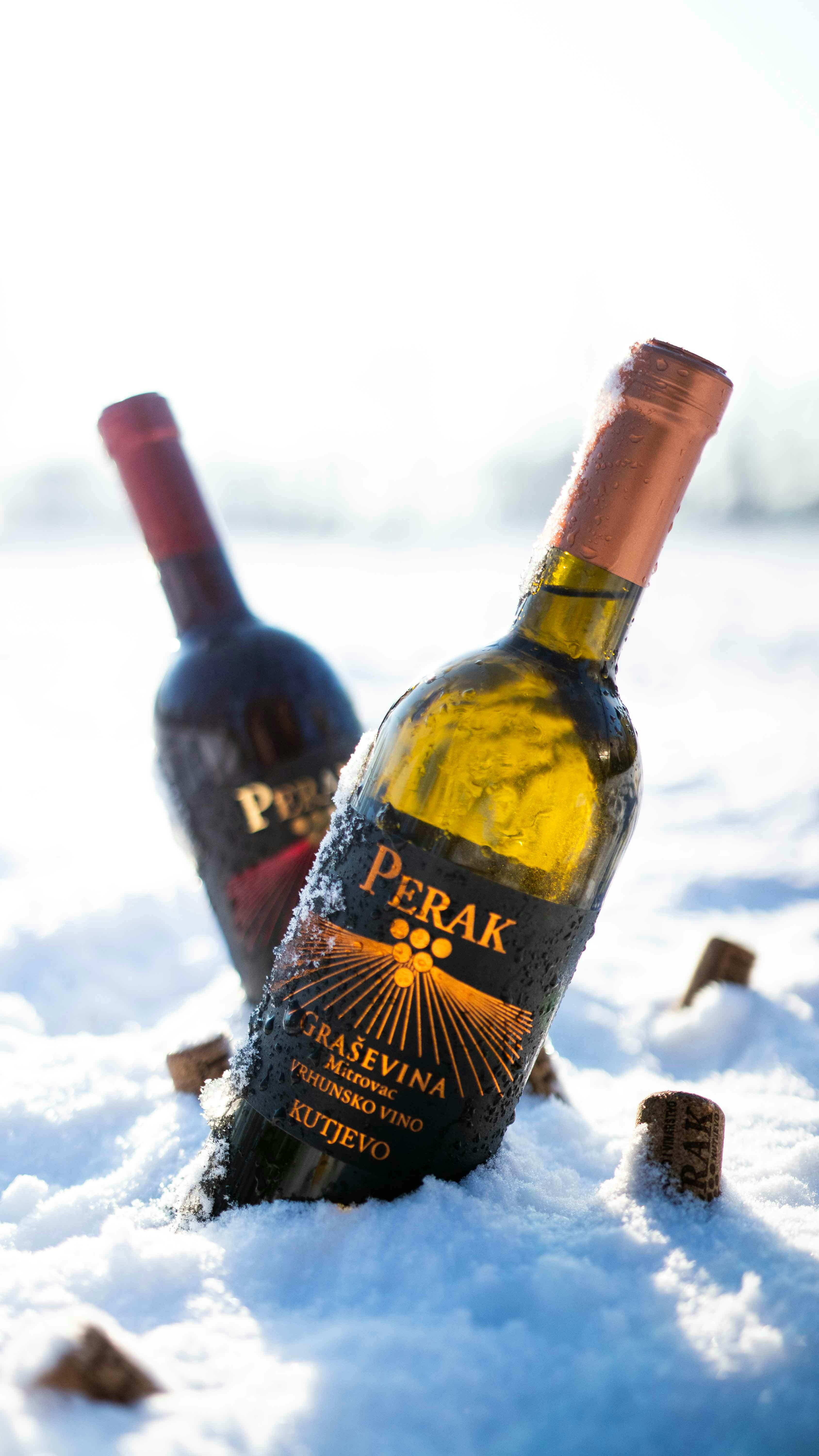two bottles of wine sitting in the snow
