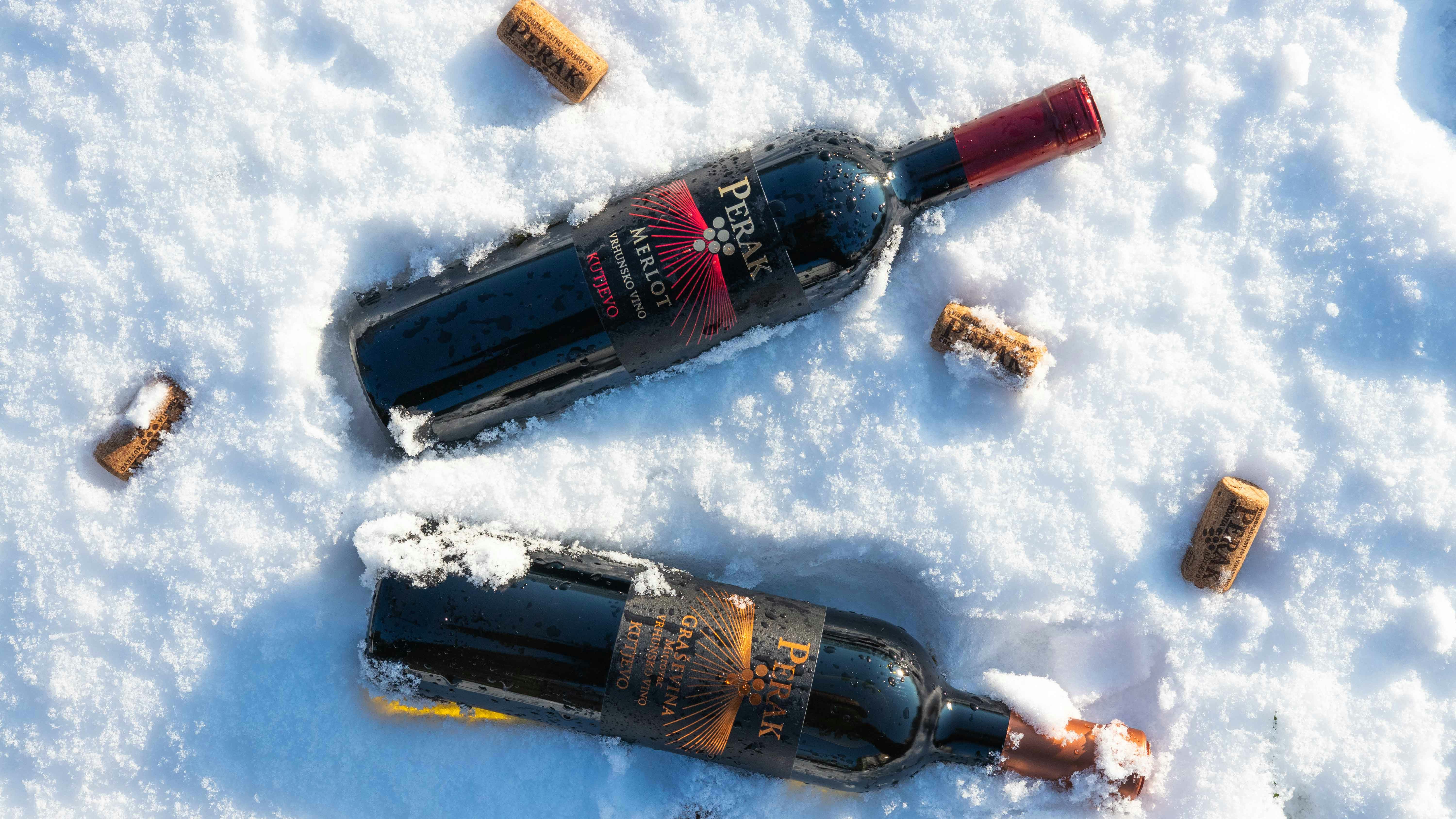 two bottles of wine sitting in the snow