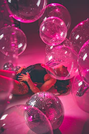 a woman laying on the ground surrounded by disco balls