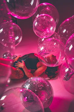 a woman laying on the ground surrounded by disco balls