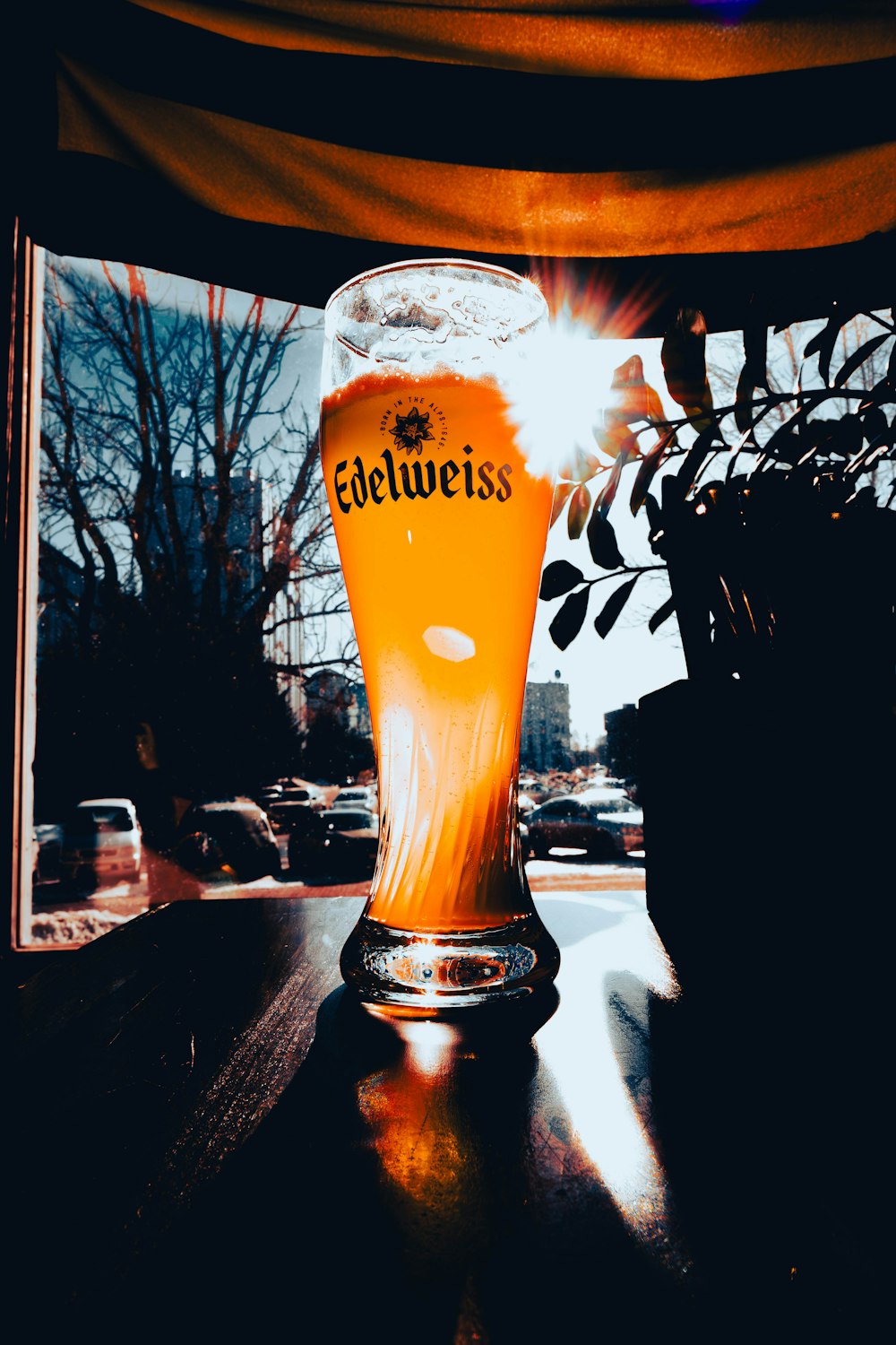 a glass of beer sitting on top of a wooden table