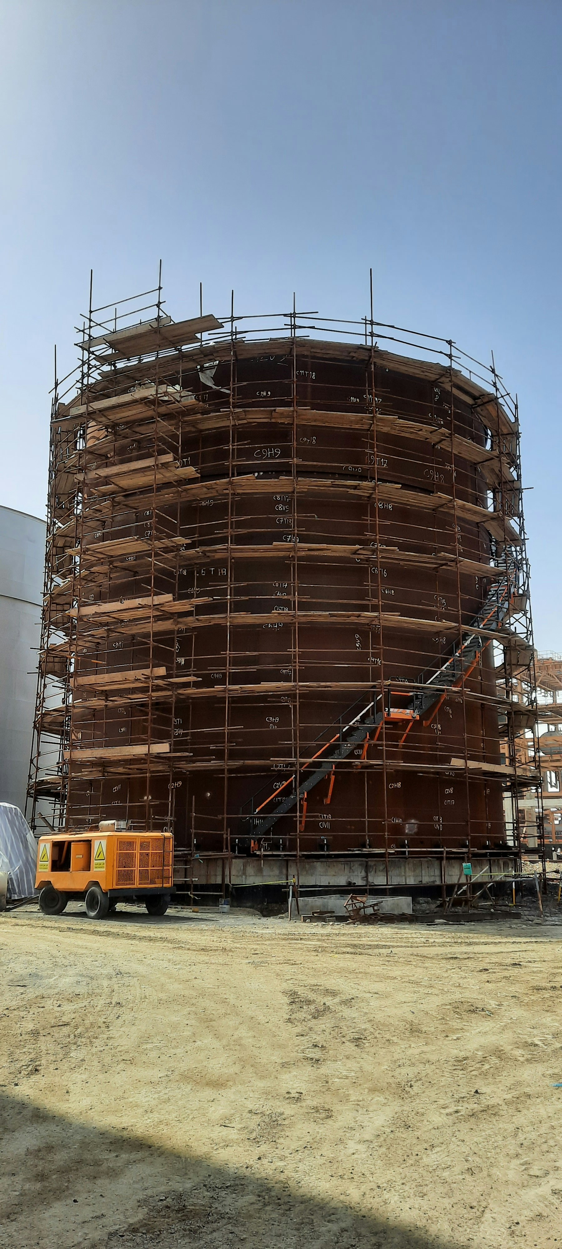 Steel fuel service tank at a construction site, industrial setting, heavy steel bunded tank with fittings