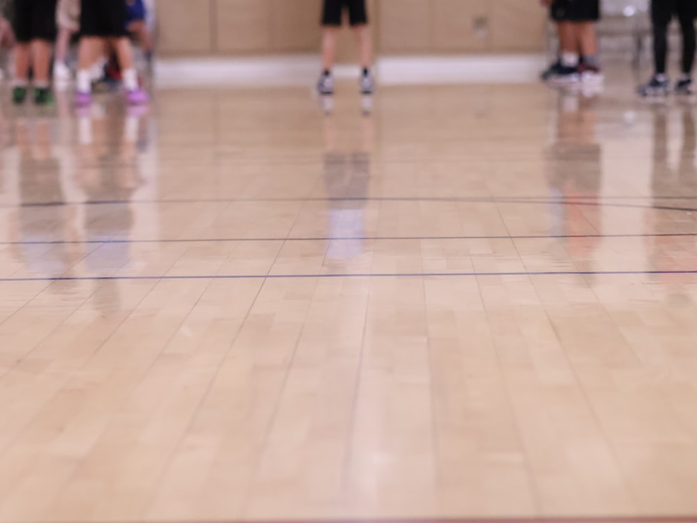 a group of people standing on top of a basketball court