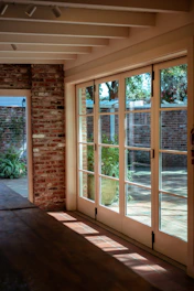 a room with a brick wall and sliding glass doors