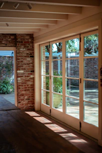 a room with a brick wall and sliding glass doors