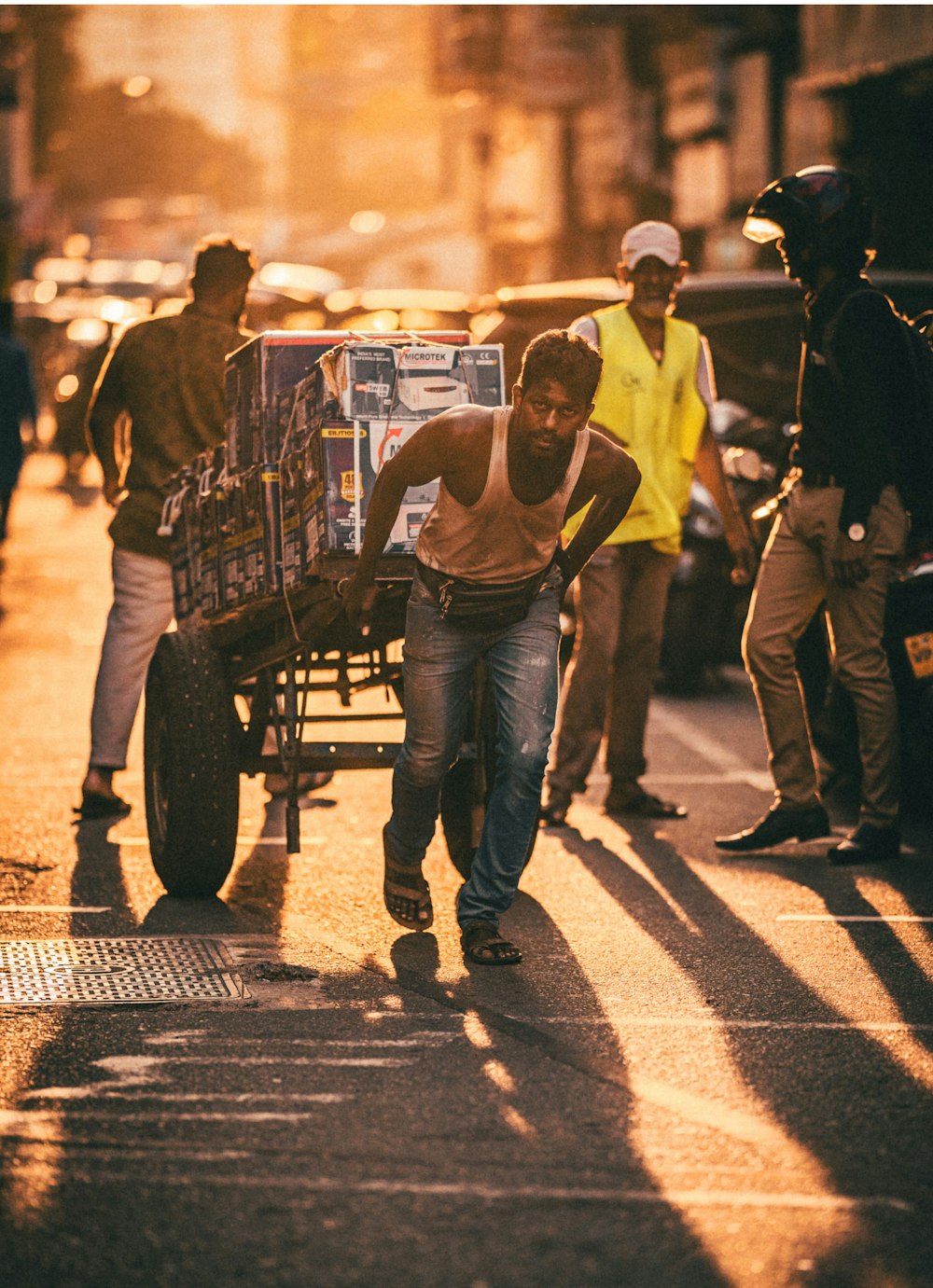 a man pushing a cart down a street