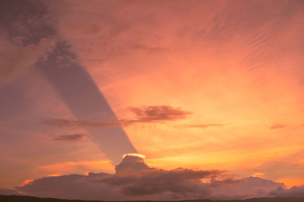 the sun is setting over a mountain range