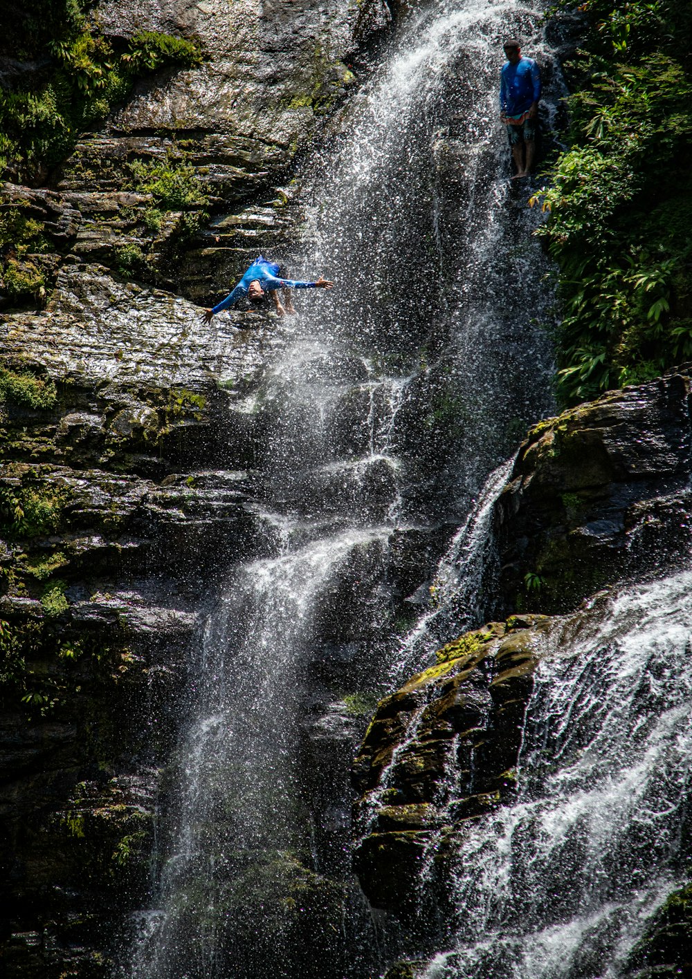 um homem caindo de uma cachoeira em um rio