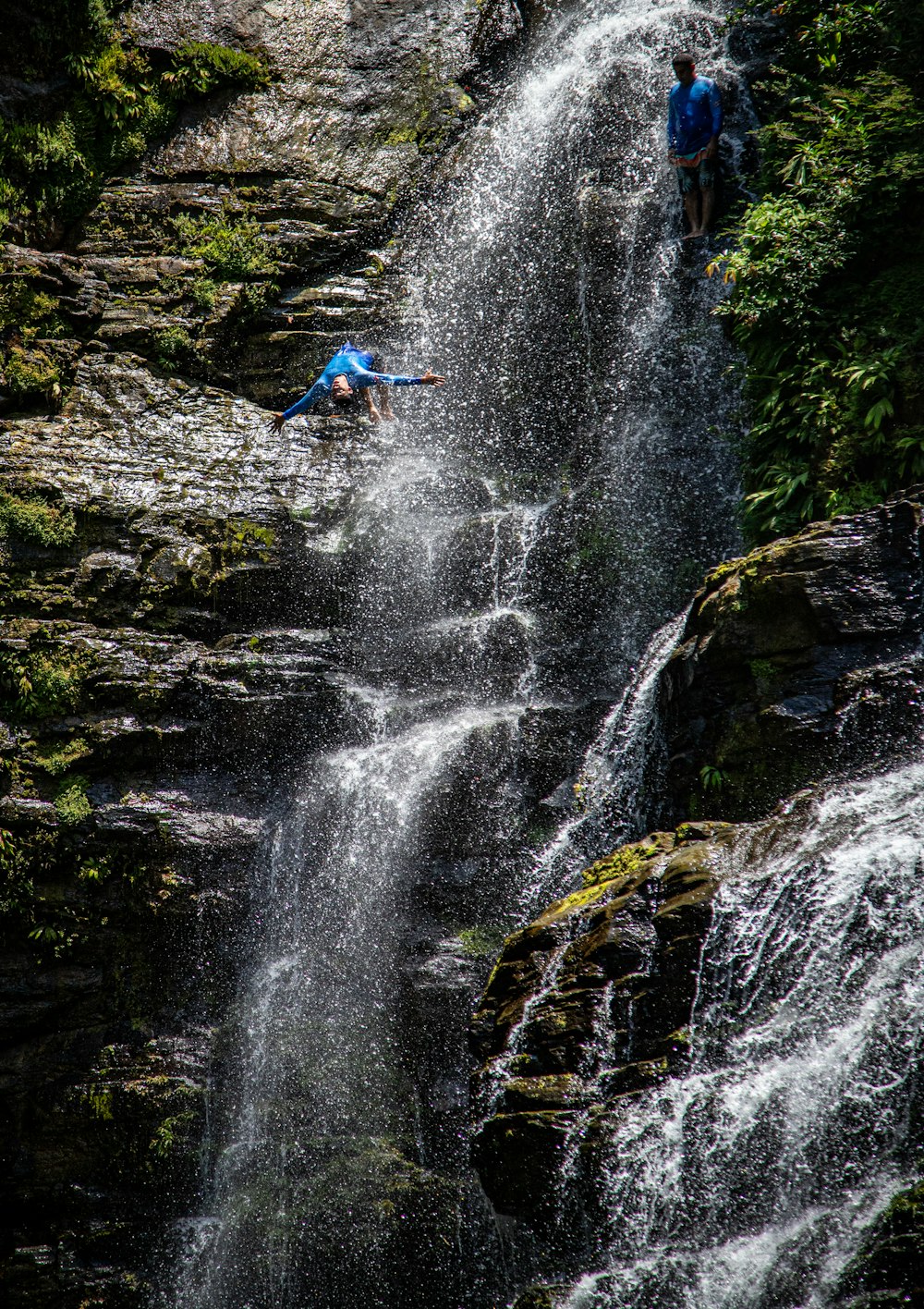 a man falling off of a waterfall into a river