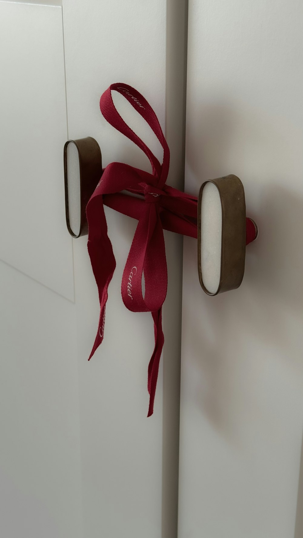 a red ribbon tied to a white door
