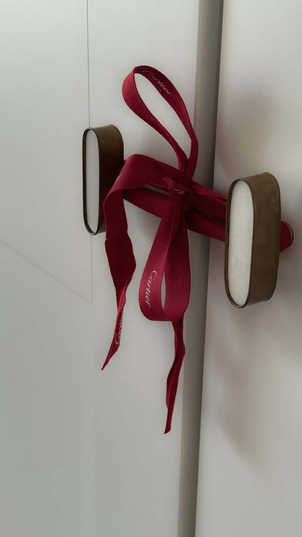 a red ribbon tied to a white door