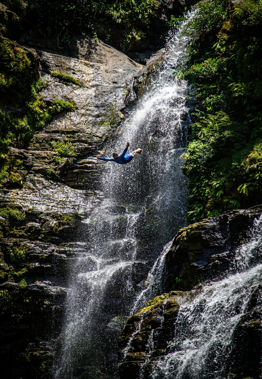 a man falling off of a waterfall into a river