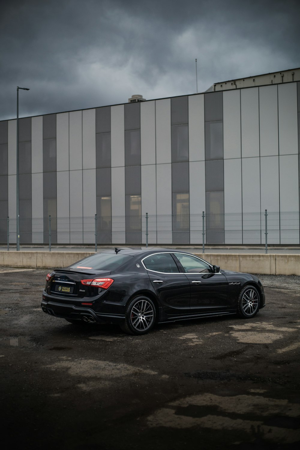 a black car parked in a parking lot next to a building