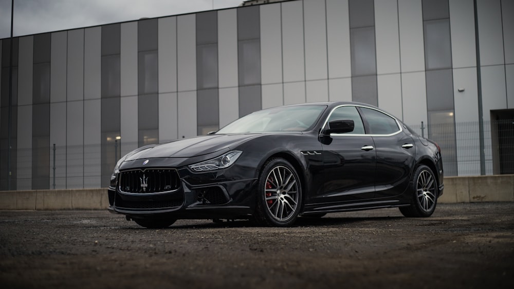 a black masera is parked in front of a building