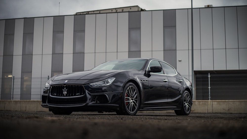 a black masera is parked in front of a building