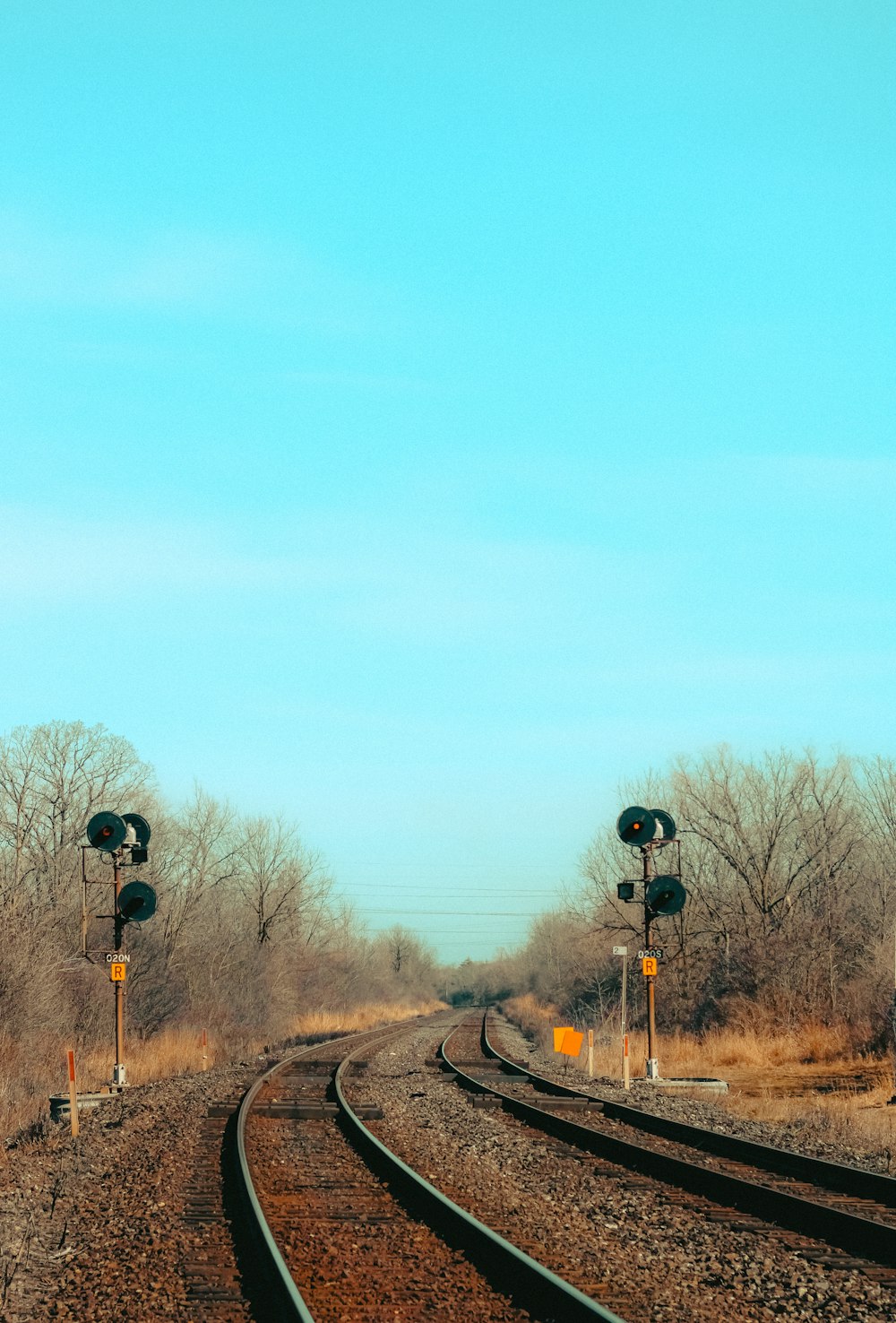 a train track with railroad crossing signals on each side