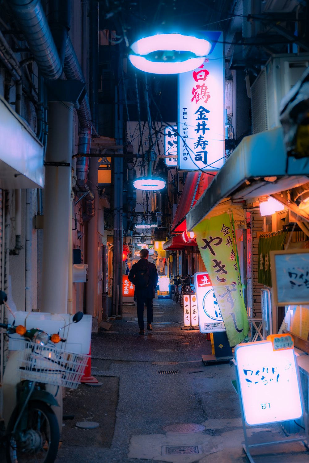 a man walking down an alley way at night